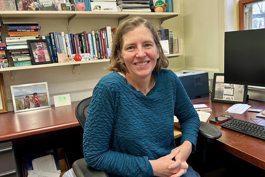 Diana Mason is shown in her office sitting and smiling to the camera. 
