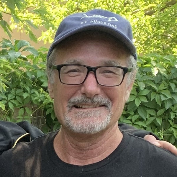 Bob Parker. Shows a man with glasses and hat in front of a bunch of different green plants. 